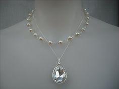 "Beautiful necklace features a huge A rhinestone set on silver plated mount hang on a sterling silver chain. The other strand made with hand wire wrapped light cream swarovski pearls. Finished with a sterling silver clasp with 1.5\" extension chain.   Pendant measures about 22mm x 35mm  For full Isabella Collection, please check here: http://www.etsy.com/shop/blissbridal1/search?search_query=Isabella&search_submit=&search_type=user_shop_ttt_id_6877408&shopname=blissbridal1" White Bridal Necklace With Bling As Gift, White Bling Bridal Necklace Gift, White Rhinestone Sterling Silver Necklace, Wedding Pendant Necklace With Bling, Silver Rhinestone Jeweled Necklace For Anniversary, Silver Rhinestone Necklace With Jewels For Wedding, Silver Rhinestone Necklace With Jewels For Anniversary, Silver Rhinestone Necklace For Anniversary, Silver Rhinestone Anniversary Necklace