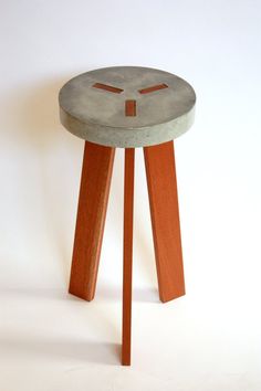 a small stool made out of concrete and wooden legs with holes in the top, on a white background