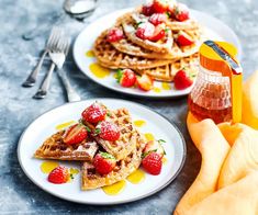 two plates with waffles and strawberries on them