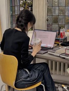 a woman sitting at a desk using a laptop computer