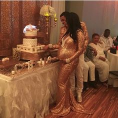 a man and woman in gold sequins cutting a cake at a wedding reception