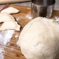 a ball of dough sitting on top of a wooden cutting board