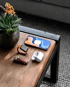 an apple watch, cell phone and other electronics on a coffee table in a living room