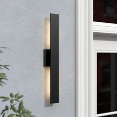 an outdoor light that is on the side of a wall next to a door and window