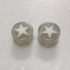 two silver and white stars are on top of each other