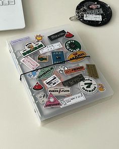 a laptop computer sitting on top of a desk next to a bunch of stickers