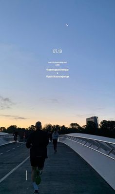 a man running across a bridge with the sun setting in the background and people walking on it