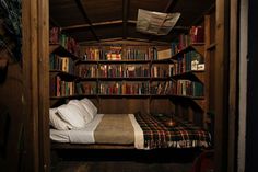 a bed in a room with lots of books on the shelves