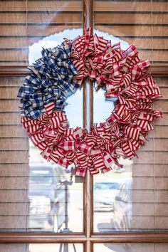 an american flag wreath is hanging on the window sill in front of a building