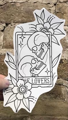 someone holding up a sticker that says it lovers on the side of a brick wall