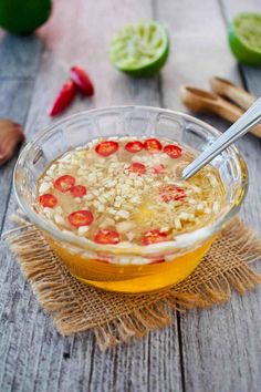 a bowl filled with food sitting on top of a wooden table next to garlic and peppers