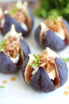 figs with nuts and cheese are on a white plate