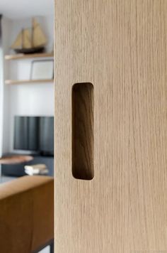 a close up of a door handle on a wooden door in a room with shelves