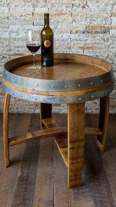 a wine barrel table with a glass of wine on it and a bottle in the middle