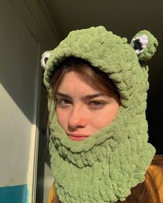 a woman wearing a green frog hat and scarf