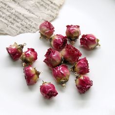 several pieces of red glass sitting on top of a white plate next to a piece of paper