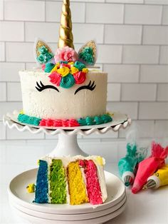 a rainbow unicorn cake with a slice missing from it