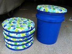 three blue containers sitting next to each other on the ground, one with a green and blue polka dot cover