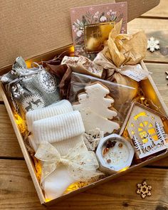 an open box filled with assorted items on top of a wooden table next to snowflakes