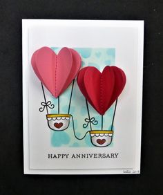 two heart shaped hot air balloons on top of a card with the words happy anniversary