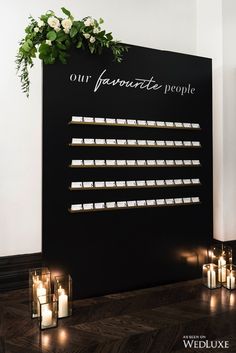 candles are lit in front of a sign that says our favorite people on the wall