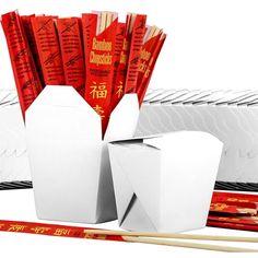 an assortment of chinese snacks and chopsticks on a white background with red packets