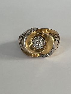 a gold and silver ring with a diamond in the center