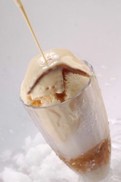 an ice cream sundae in a tall glass with a straw sticking out of it