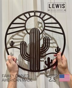 two hands are working on a metal cactus wall art piece with the words family owned american made in front of it