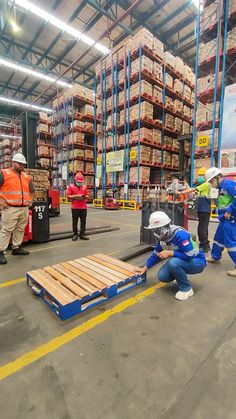 workers are working on pallets in a warehouse