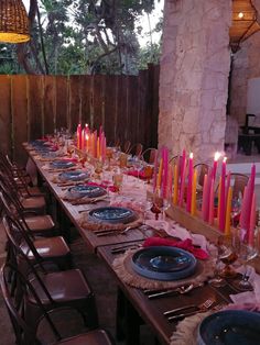 a long table is set with candles and place settings for an outdoor dinner or party