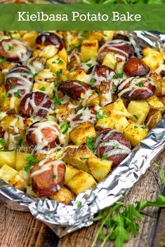 kelebasa potato bake with melted cheese on top and fresh herbs in the background