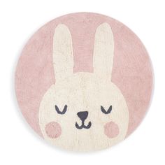 a pink rug with a white bunny face on the front and black eyes in the middle