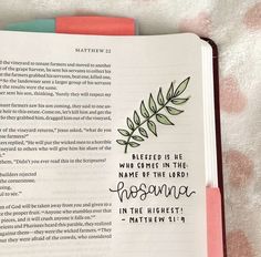 an open bible with the words, and green leaves on it's pages