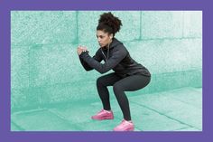 a woman squatting in front of a green wall