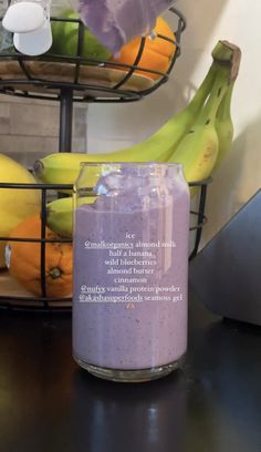 a glass jar filled with purple liquid next to bananas