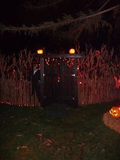 an outhouse decorated for halloween with pumpkins and lights