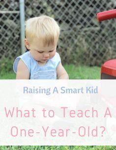 a toddler sitting in the grass playing with a toy truck and reading a book