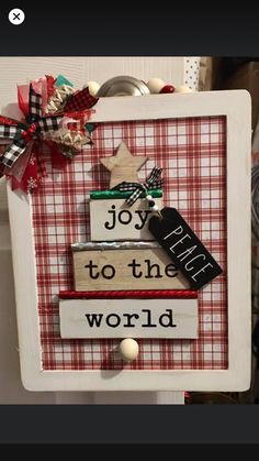 a wooden sign that says joy to the world with some decorations on top of it