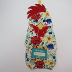 an oven mitt with flowers on it and a tag attached to the back of it