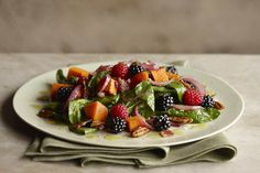 a white plate topped with salad and fruit