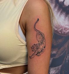 a woman's arm with a tiger tattoo on the left side of her body