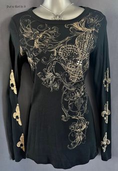 New Womens Vocal Apparel embellished black fleur di lis cotton long sleeve tee shirt Size Extra Large This incredibly unique and rare Vocal shirt is just stunning Design on front and one sleeve embellished in crystals  Black and taupe toned Just GORGEOUS Made in USA by Vocal Apparel This is one of my many HIGHLY sought after old school Vintage Vocal style tops Sold out with Vocal/Discontinued Design You won't find this top ANYWHERE else I have been selling Vocal clothing for 17 YEARS now and just LOVE this brand! Please see measurements 100% Cotton - Has Stretch Measured without stretching - *Large - 15" armpit to armpit unstretched - 26" in length *XLarge - 16" armpit to armpit unstretched - 27" in length BE VOCAL - STAND OUT IN A CROWD & PUT A GIRL IN IT before it's gone! XOXO Lisa - Put Embellished Long Sleeve Tops For Winter, Winter Embellished Long Sleeve Tops, Fitted Rhinestone Tops For Fall, Black Long Sleeve Tops With Rhinestones, Dr Wardrobe, Crystals Black, Embellished Shirt, Style Tops, Long Sleeve Tee Shirts