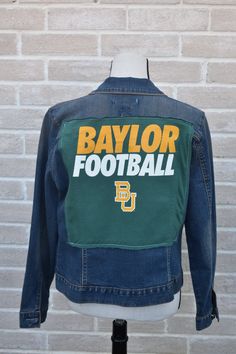 Baylor Football Repurposed Vintage Jean Jacket with a Hand-Stitched heart on the sleeve. Sic 'Em Bears! This jacket fits like a M-L. Step into the world of Repurposed Vintage Jean Jackets, Flannels, Military Jackets, & Military Flight Suits where fashion meets sustainable innovation! These carefully curated pieces have been meticulously sourced and transformed, breathing new life into forgotten fabrics. - These one-of-a-kind creations are not replicated; instead, they are reinvented into a uniqu College Denim Jacket For Fall, Fall Denim Jacket For College, Fitted Outerwear With Embroidered Patch For Fall, Fitted Fall Outerwear With Embroidered Patch, Fall Long Sleeve Outerwear With Collage Stitching, Fitted Long Sleeve Outerwear With Patches, Painting Denim, Baylor Football, Flight Suits