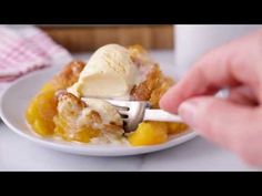 a person is holding a fork over a piece of fruit cobbler with ice cream on top