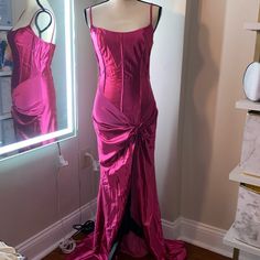 a mannequin with a pink dress on display in front of a mirror