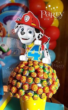 a birthday cake made to look like a dog on top of a cup filled with candy