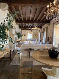 a living room filled with lots of furniture and a chandelier hanging from the ceiling