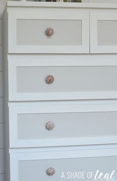 a white dresser with drawers and knobs on it