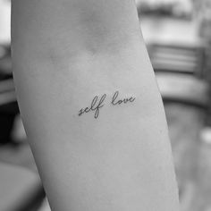 a woman's arm with the word self love tattooed on it